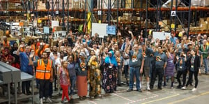 QuickBox team waving from the warehouse floor