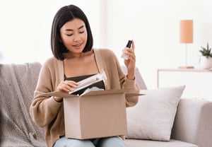 Woman on the sofa opening a box